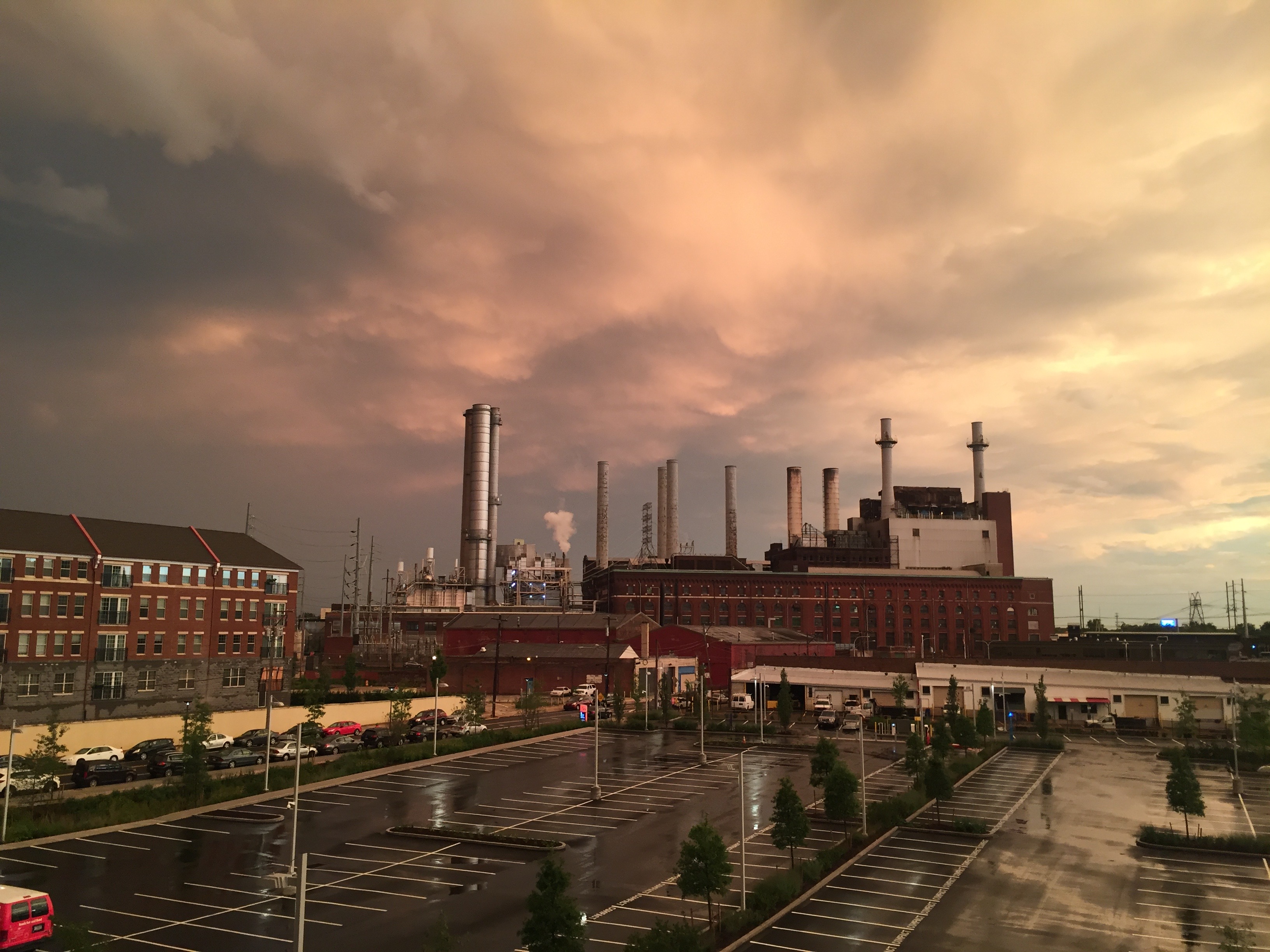 Smokestacks under a storm sky at sunset